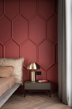 a bedroom with red walls and gold accents, including a bed in the foreground