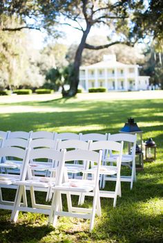 rows of white folding chairs sitting in the grass