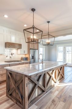 a large kitchen with an island made out of wooden planks and lights hanging from the ceiling