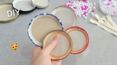 someone is holding three empty plates on a table with beads and other items around them