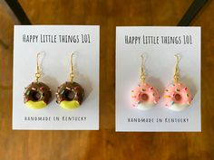 two earrings with donuts and sprinkles on them are shown in front of a card that says happy little things do