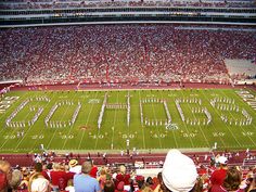 a football stadium filled with lots of fans and people watching the band on the field