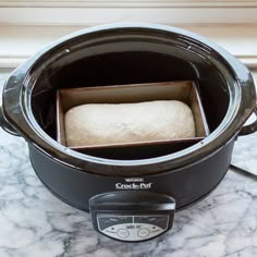 an open crock pot with bread in it