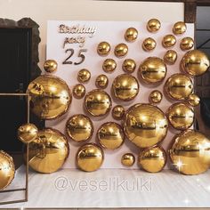 there are many shiny gold balloons on display