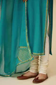 Teal blue full sleeves straight kurta in chanderi base with sequin tikki jaal embroidery on the neckline, sleeves hem and borders. Paired with ivory cotton churidar and embroidered viscose organza dupatta.
Components: 3
Pattern: Embroidery
Type Of Work: Sequin Tikki Jaal
Neckline: Round
Sleeve Type: Full
Fabric: Kurta: Chanderi, Dupatta: Viscose Organza, Churidar: Cotton
Color: Blue
Other Details: 
Length:
Kurta: 46inches
Churidar: 58inches
Dupatta: 2.5metres
Occasion: Puja - Aza Fashions Jaal Embroidery, Cotton Churidar, Chanderi Dupatta, Blue Kurta, Straight Kurta, Pattern Embroidery, Organza Dupatta, Churidar, Full Sleeves