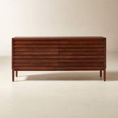 a large wooden dresser sitting on top of a white floor next to a brown wall