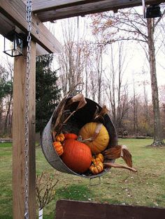 a hanging basket filled with pumpkins and gourds