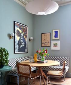 a living room filled with furniture and pictures on the wall next to a dining table