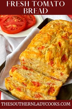 a loaf of fresh tomato bread on a plate with tomatoes in the background and text overlay