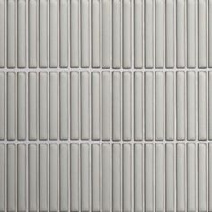 a white tile wall with vertical lines on it