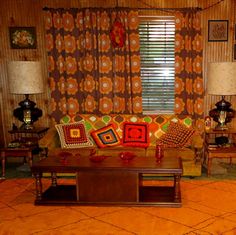 a living room filled with furniture and colorful pillows on top of it's couches