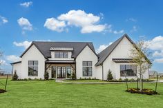 a large white house sitting on top of a lush green field