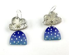 two small blue and white earrings with dots on the top, one in the shape of a flower