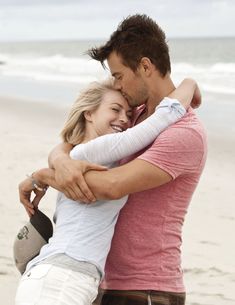 a man and woman hugging on the beach