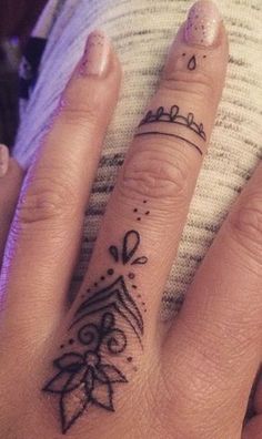 a woman's hand with a tattoo on it and a ring in the middle