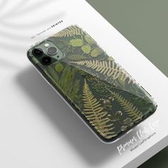 an iphone case with green leaves on it