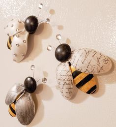 three bees are hanging on the wall next to each other with writing written on them