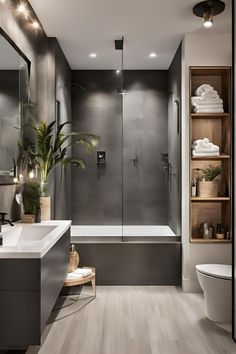 a modern bathroom with gray walls and wood flooring on the shower, tub, toilet and sink