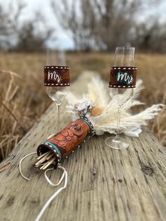 two wine glasses sitting on top of a wooden table next to an object with writing on it