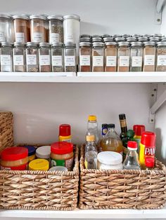 an organized pantry with spices and condiments in baskets on the shelves, along with other kitchen items