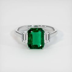 The ring features a beautiful, transparent 2.45 carat emerald cut shape green emerald with the dimensions of 9.65 x 7.48 x 4.29 mm and a emerald cut. It has a clarity grade of very slightly included (evaluated at eye level), vivid color saturation, and an excellent polish. #emeraldengagement #emeraldweddingring #emeraldengagementringgreen #ringsengagementemerald #greendiamondring Luxury White Gold Emerald Ring For May Birthstone, Gia Certified Emerald Cut Emerald Ring For May Birthstone, Gia Certified Baguette Cut Emerald Ring For May Birthstone, Modern Emerald Cut Emerald Ring, Modern Emerald Ring, Modern Green Emerald Diamond Ring, Octagon Green Emerald Ring, Octagonal Green Emerald Ring, Green Octagon Emerald Ring