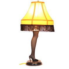 a lamp that is sitting on top of a wooden base and has a yellow shade