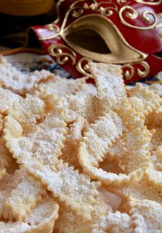 powdered sugar cookies on a plate with a red mask in the backgroud