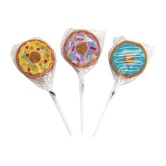 three candy lollipops with frosting and sprinkles on them