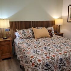 a bed sitting in a bedroom next to two lamps on either side of the bed