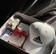 a hat and other items are sitting in a box with a bow on the side