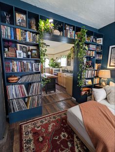 a bed sitting in a bedroom next to a bookshelf filled with lots of books