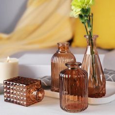 vases and candles are sitting on a tray