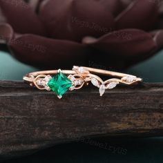 a close up view of a ring with an emerald stone and white diamonds on it