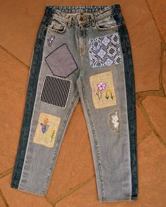 a pair of jeans with patches and flowers on them