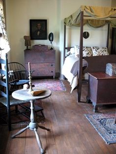 an old fashioned bedroom with four poster bed and antique furniture in the corner, along with other furnishings