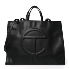 This is an authentic TELFAR Vegan Leather Large Shopping Bag in Black.This is a tote crafted of synthetic leather in black with the iconic raised Telfar logo at the front. The shoulder bag has short top handles, and two long shoulder straps. The top secures with a magnet snap and opens toa black fabric-lined interior with a zippered pocket.