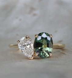 two engagement rings, one with an oval cut and the other with a pear shaped diamond