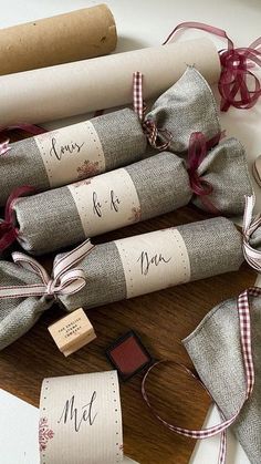 rolled up wrapping paper on top of a wooden cutting board next to other wrapped items