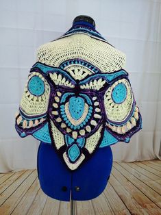 an elephant head made out of crochet on a mannequin stand with a white curtain behind it