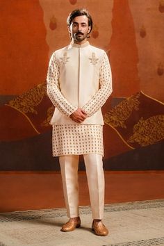 Ivory bundi with baug taj embroidered motif. Paired with an inner pineapple print kurta and pant. Comes along with a veshti with dandelion embroidery. - Aza Fashions White Nehru Jacket For Diwali Reception, White Nehru Jacket For Reception Diwali, Cream Nehru Jacket For Ceremonial Festivals, Fitted White Sherwani With Gota Work, Ceremonial Cream Nehru Jacket For Festivals, White Fitted Sherwani With Gota Work, White Nehru Jacket With Pallu For Festivals, White Nehru Jacket With Intricate Embroidery For Reception, Elegant White Sherwani With Gota Work