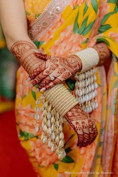 a close up of a woman's hands with hennap and bracelets