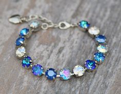 A gorgeous new bracelet made with Swarovski crystal. The bracelet features 8mm crystals ranging in color from royal blue de lite, royal blue, aqua transmission, crystal moonlight, and bermuda blue color. Crystals are hand set into a premium bracelet setting, and prong set. Bracelet will adjust to fit wrist sizes 6 inches and up. Please choose desired metal finish at checkout. Shown in silver in images above. ** Nickel and lead free Blue Crystal Bracelet, Set Bracelet, Stacked Necklaces, Crystal Bracelet, Tennis Bracelet, Blue Crystals, Chain Link Bracelet, Crystal Bracelets, Bracelet Making