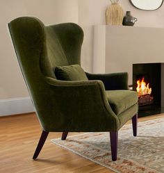 a green chair sitting in front of a fire place