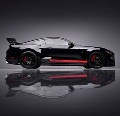 a black sports car with red stripes on it's hood is shown in front of a reflective surface