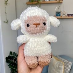 a person holding a small stuffed animal in their hand