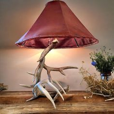 a lamp that is sitting on top of a table next to a vase with flowers