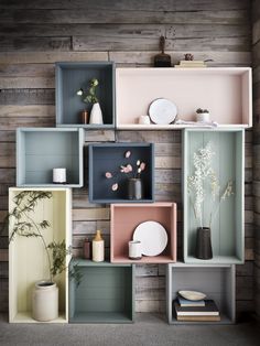 the shelves are filled with vases, plates and other decorative items in pastel colors