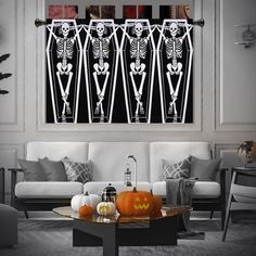 a living room decorated for halloween with skeletons and pumpkins