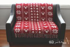 a red and white blanket sitting on top of a black chair