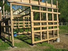 a wooden structure sitting on top of a lush green field